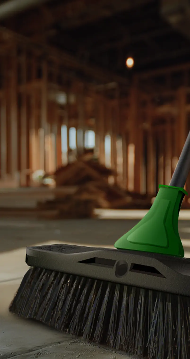 A broom being pushed on a concrete floor